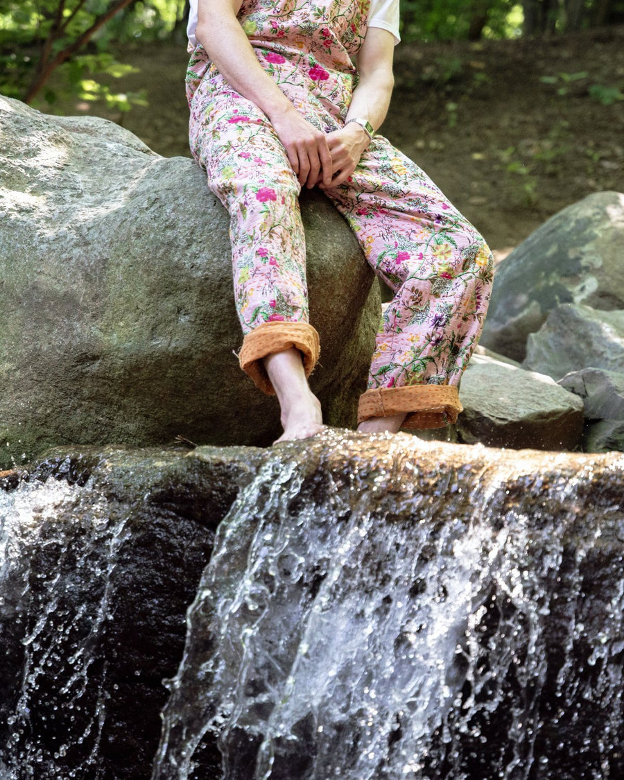 Floral overalls seated above a waterfall