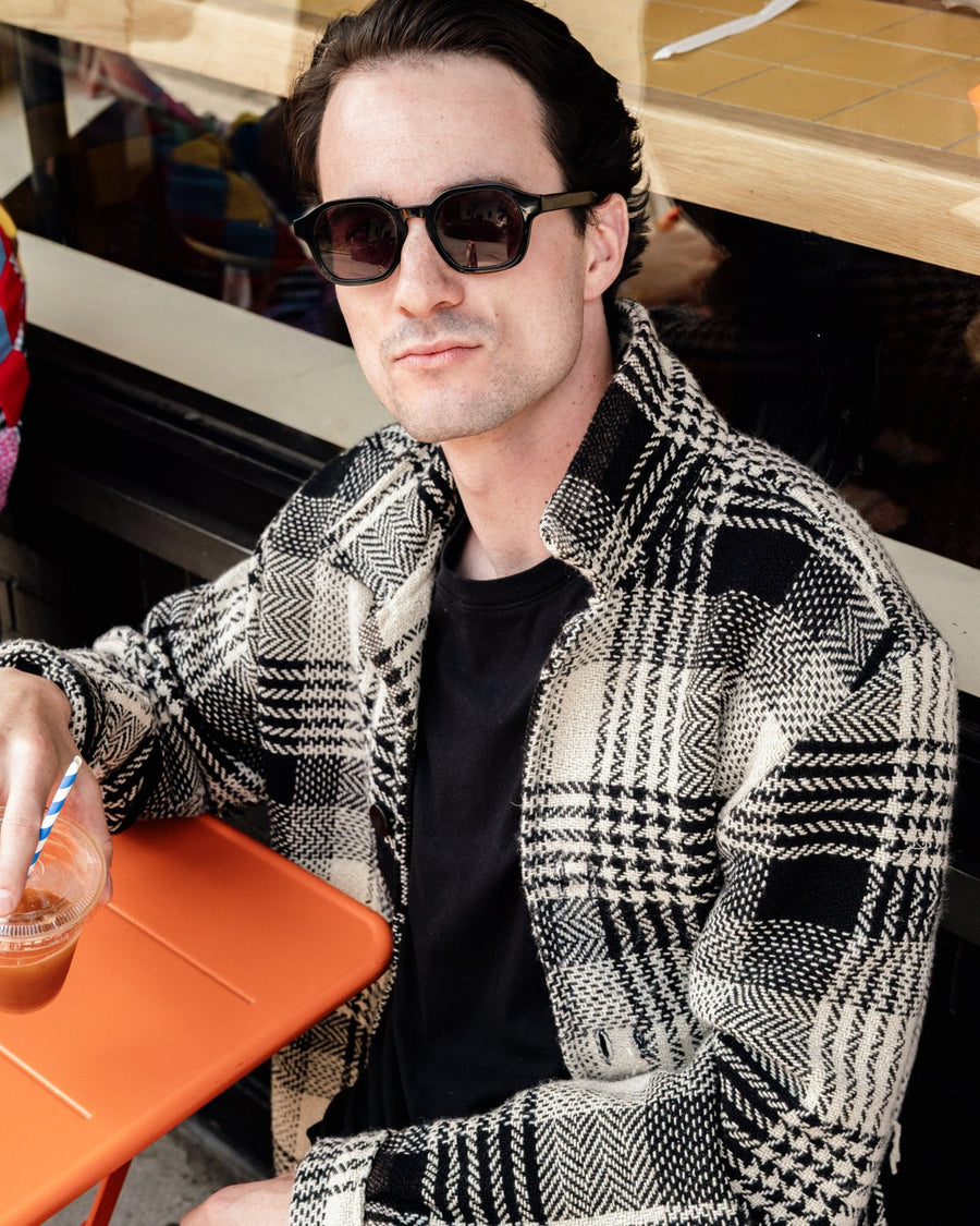Black and white checked jacket at an outdoor cafe table